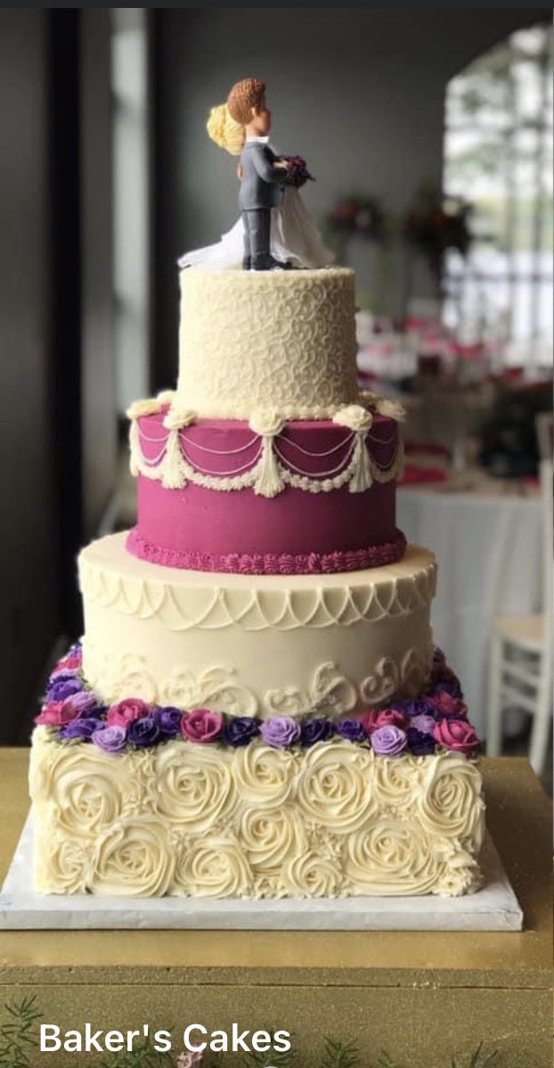 a multi tiered wedding cake decorated with bride and groom figurines on top