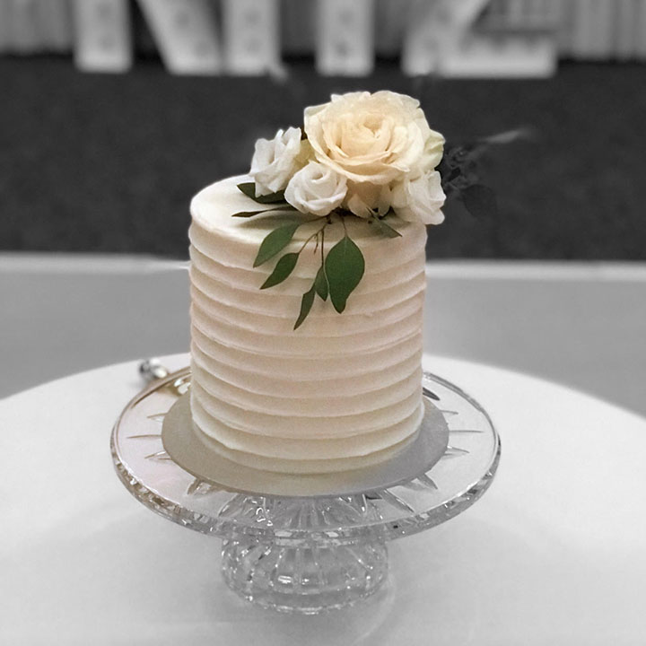 tall wedding cake with a floral style decoration on top