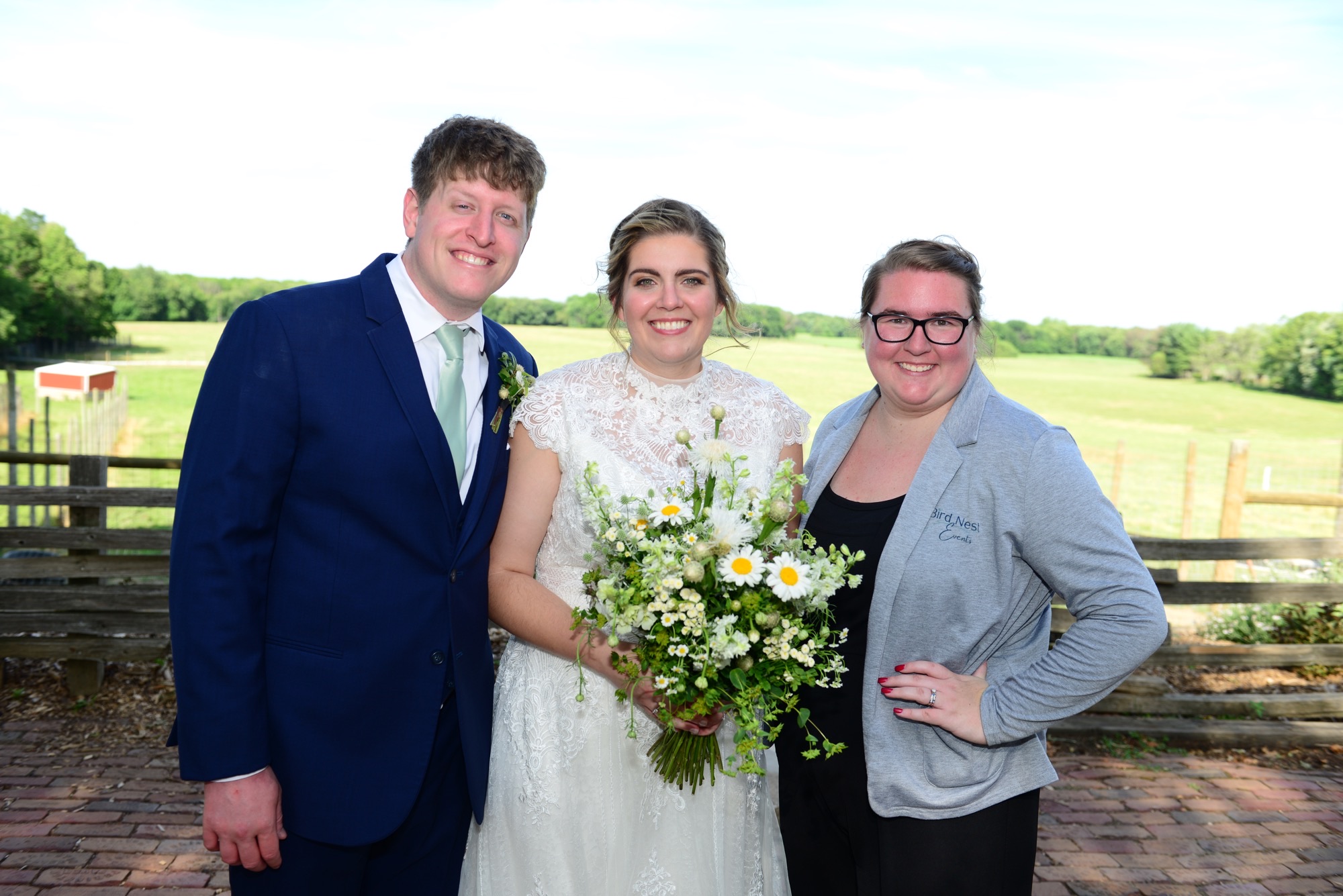 Hannah standing with a wedding couple