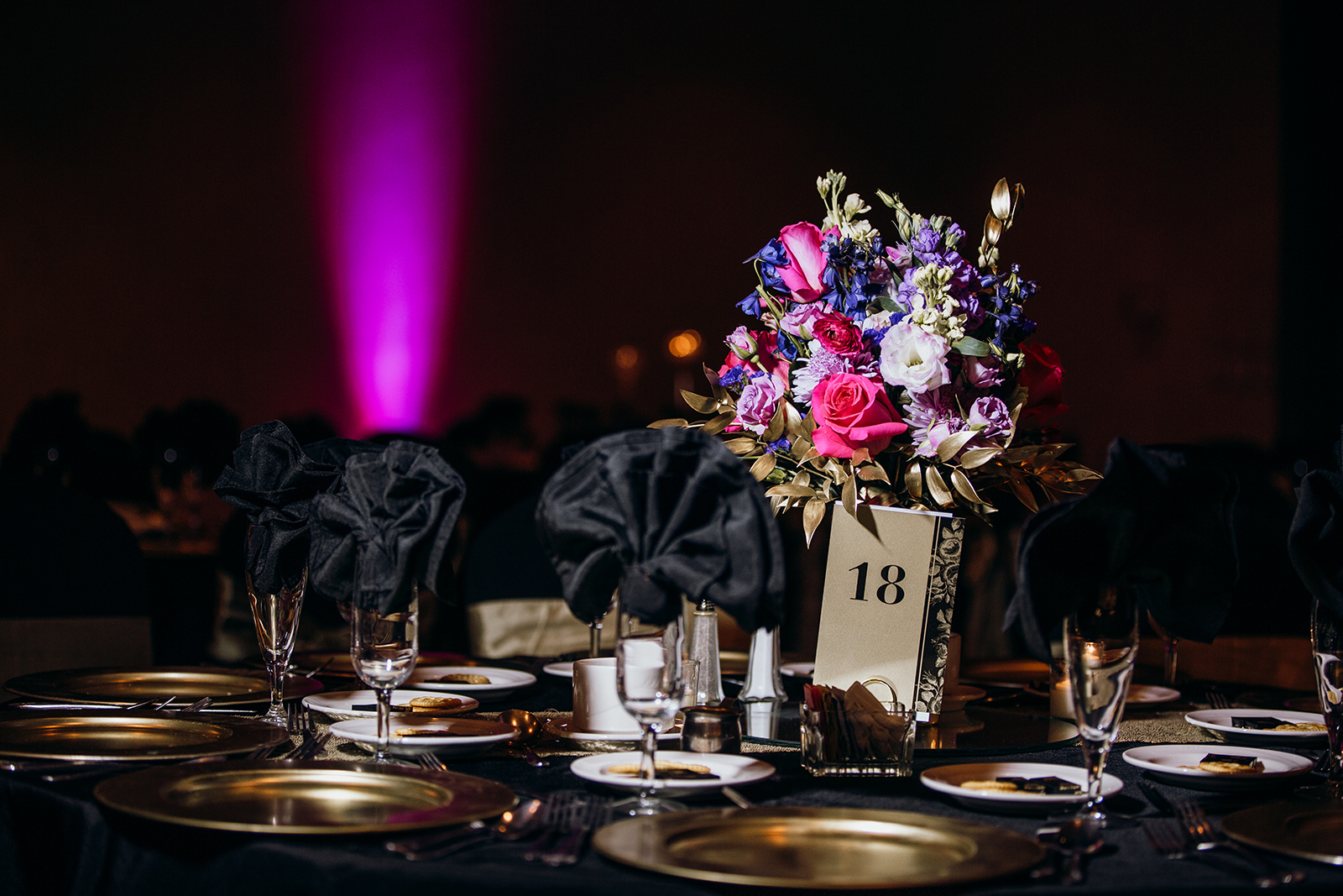 a table set with dinnerware in preparation for a wedding reception