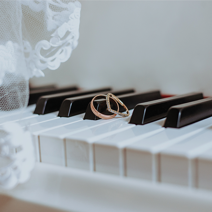 wedding rings sitting on piano keys