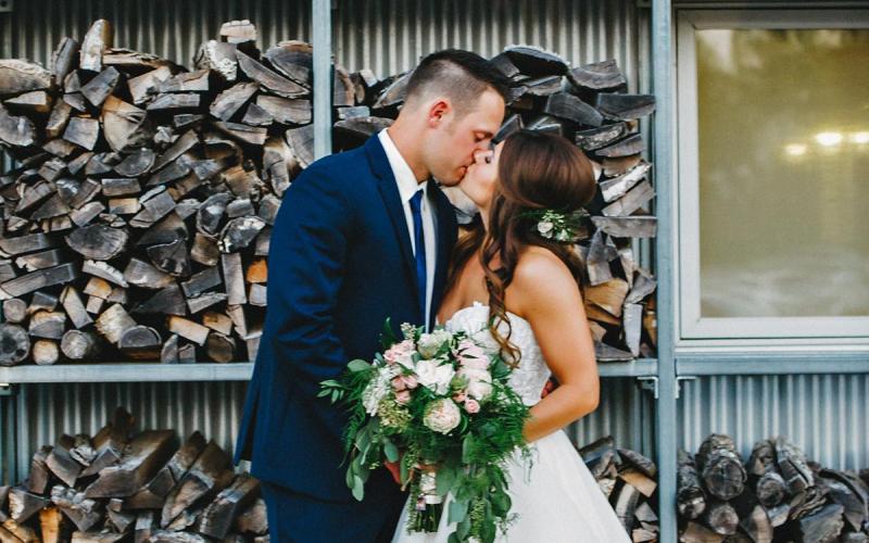 a bride and groom kissing outside Firefly Grill