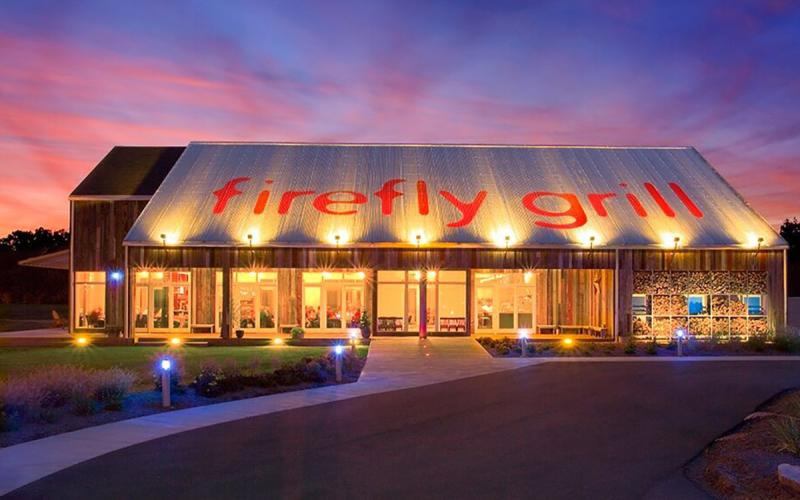 view of Firefly Grill from outside at night with lights on