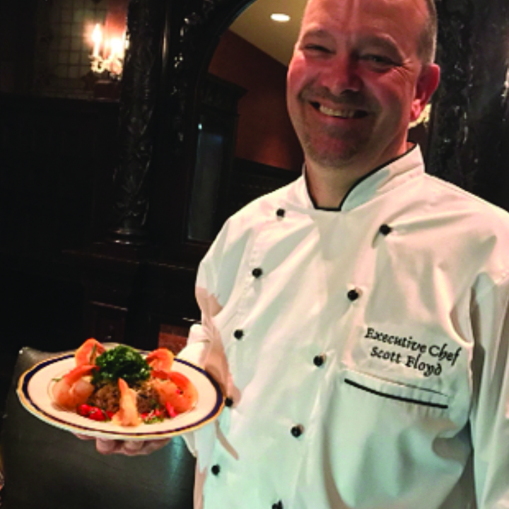 the executive chef holding a plate of food just prepared